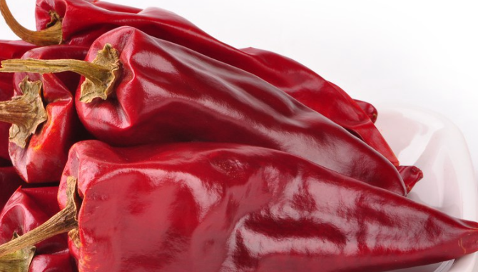 Grinding dried red pepper pods into custom spice blends