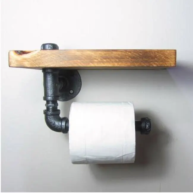 Black wrought iron pipes and floor flange used in toilet paper holder