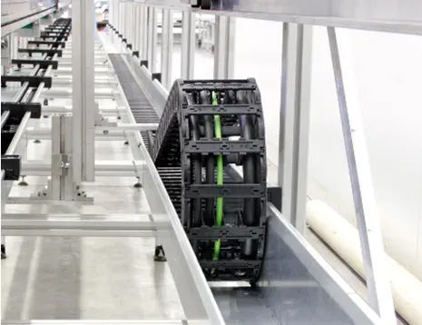 Flexible plastic cable carrier chain for managing and protecting cables within machinery.