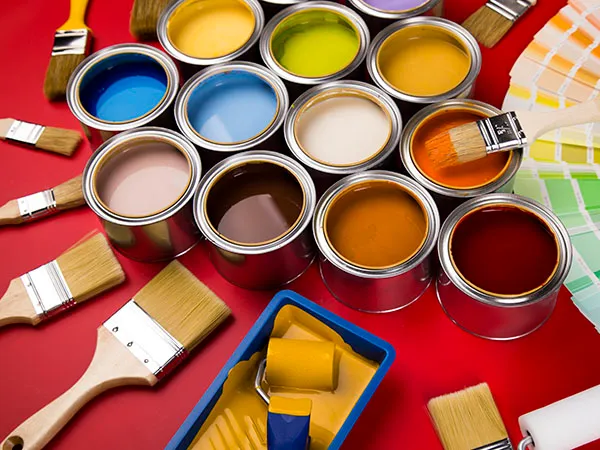 Full Buckets of rainbow colored oil paint on red background